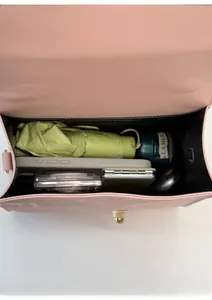 Detail view of the pink leather crossbody bag interior showing spacious storage and golden lock