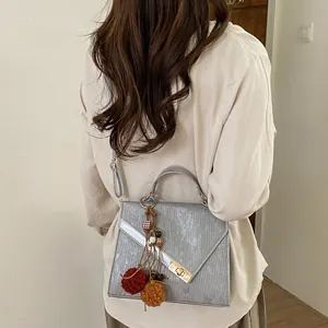 Silver-gray crossbody bag with vertical texture and golden square twist lock