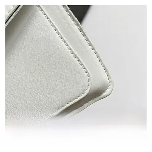 Macro detail of premium white faux leather with fine stitching and lychee grain texture
