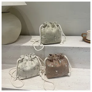 Detail von gewebten Beuteltaschen mit Blumenstickerei in Grün, Weiß und Braun