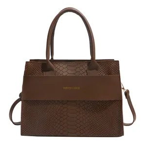 Dark brown faux crocodile skin tote bag with gold lettering and top handles