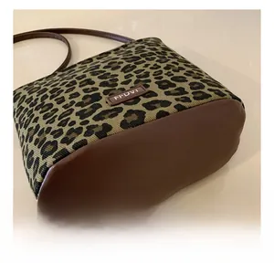 Detailed view of leopard print bucket bag stitching and faux leather base panel