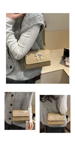 Close-up of beige crocodile pattern bag featuring a golden butterfly metal clasp and chain