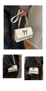 Detail of white crocodile texture leather bag with golden butterfly buckle and chain strap