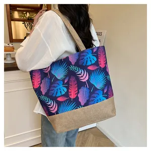 Close-up of a large tote bag with vibrant tropical leaf print and natural linen details