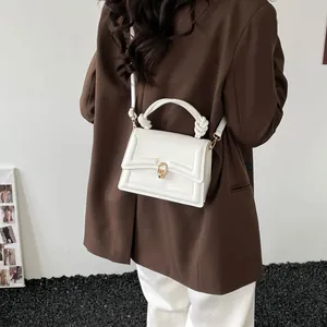 Minimalist white leather square handbag for women with gold clasp buckle shown on model