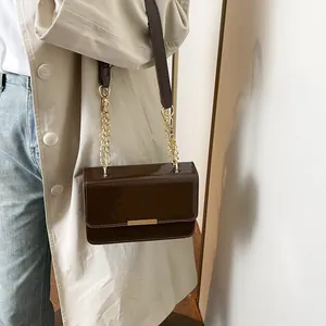 Retro dark brown patent leather crossbody bag with elegant gold chain and flap closure