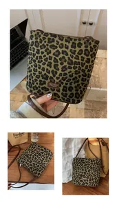 Detail shot of leopard print canvas bucket bag with brown leather strap and brand label