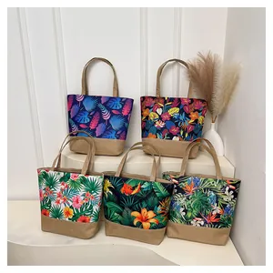 Detail of five canvas tote bags with vibrant tropical floral prints and linen stitching