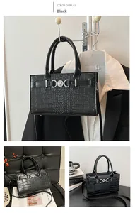 Detail of black crocodile pattern tote bag with silver hardware and detachable strap