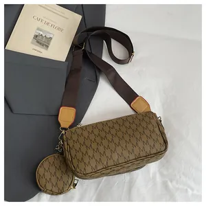 Detailed macro of a brown retro crossbody bag with M-pattern and mini coin purse charm