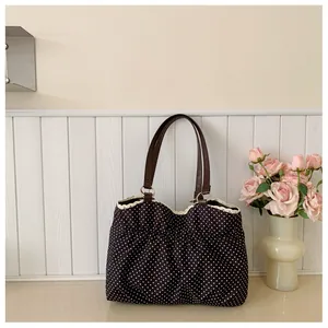 Detail of vintage polka dot tote with white lace trim and dark brown leather handle
