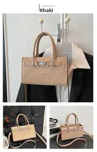 Detail of khaki crocodile pattern handbag with silver heart buckle and shoulder strap