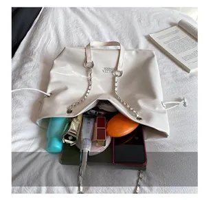Vue détaillée de l'intérieur spacieux du sac à bandoulière blanc avec objets du quotidien