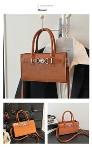 Detail view of brown crocodile texture handbag with silver metal ring and crossbody strap