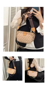 Detail view of beige multi-pouch crossbody bag with geometric pattern and wide strap