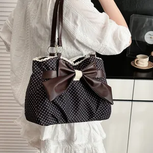 Retro polka dot tote bag with brown bow and lace trim shown in a stylish lifestyle setting