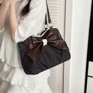 Close-up of vintage polka dot tote bag with leather bow and delicate lace trim detail