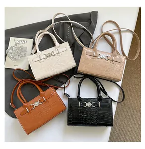 Flat lay of crocodile pattern handbags in white, beige, brown, and black colors