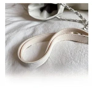 Détail de la bandoulière large et confortable avec chaîne argentée sur le sac cabas blanc