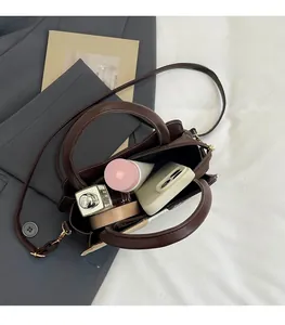 Top-down view of a brown leather bag showing spacious interior with daily essentials