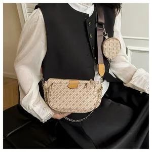 Close-up of a stylish monogram 3-in-1 crossbody bag with a round coin purse and gold chain