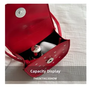Vue détaillée de la capacité du mini sac rouge à cœurs avec écouteurs et fermoir aimanté