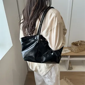 Glossy black oil wax leather tote bag with pleated design and spacious interior for women