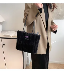 Détail du sac cabas en peluche noire avec surpiqûres verticales et logo violet
