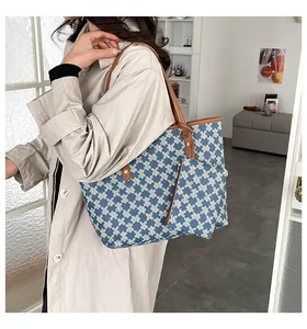 Detail of blue and white geometric print tote bag with brown leather straps and pouch