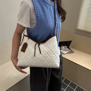 White quilted tote bag with brown leather trim and bow detail for trendy daily use