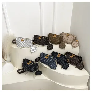 Chic monogram crossbody bag set with chain and wide strap on minimalist display