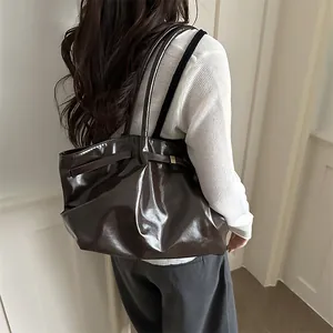 Large coffee brown glossy leather tote bag shown on model for a modern commute style