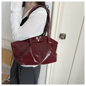 Deep burgundy glossy tote bag shown on model highlighting its large capacity and retro style