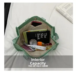 Internal capacity view of light green canvas tote bag with books and cosmetics