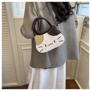 Detail view of the cute cat shaped handbag with contrast handles and shoulder strap