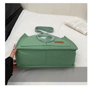 Detail view of the reinforced wear-resistant base on a green canvas tote bag