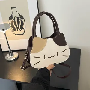 Close-up of cat-shaped handbag featuring tricolor patchwork and embroidered facial details