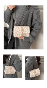 Detail of off-white quilted crossbody bag with gold S-buckle and elegant chain strap