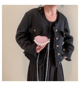 Dettaglio mini borsa rosa a forma di cuore con perle bianche e catena d'argento