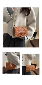 Detailed view of brown quilted leather shoulder bag with gold chain strap and tassel