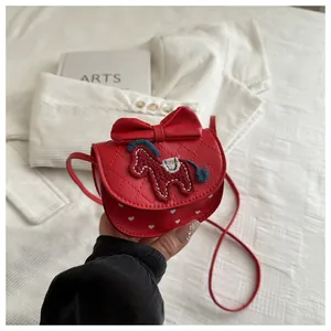 Detail van rode kinder crossbody tas met paardenborduurwerk en grote sierstrik