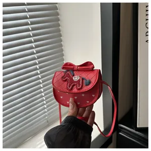 Detail van rode crossbodytas met paardenborduursel, strikaccent en gewatteerde textuur