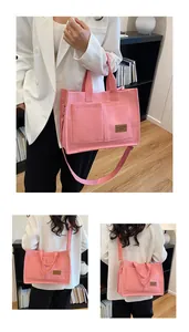 Pink canvas tote bag detail showing dual top handles and adjustable shoulder strap style
