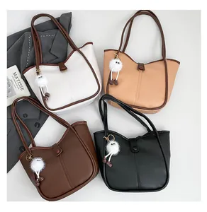 Flat lay of tote bag set in white, beige, brown and black with plush charms