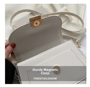 Détail du fermoir magnétique d'un sac à bandoulière blanc au design minimaliste
