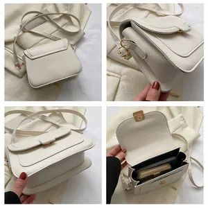 Vue détaillée du sac bandoulière beige montrant la sangle, la garniture dorée et l'intérieur