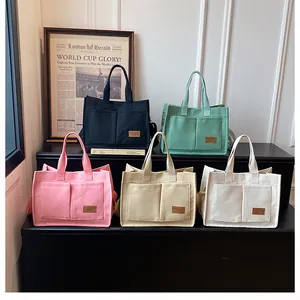 Detailed view of large canvas tote bags in five colors with functional front pockets