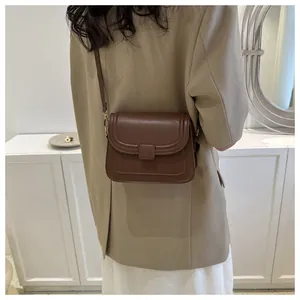 Détail du petit sac à bandoulière marron foncé minimaliste avec boucle et sangle réglable