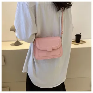 Sac à bandoulière rose minimaliste porté avec une chemise blanche style quotidien